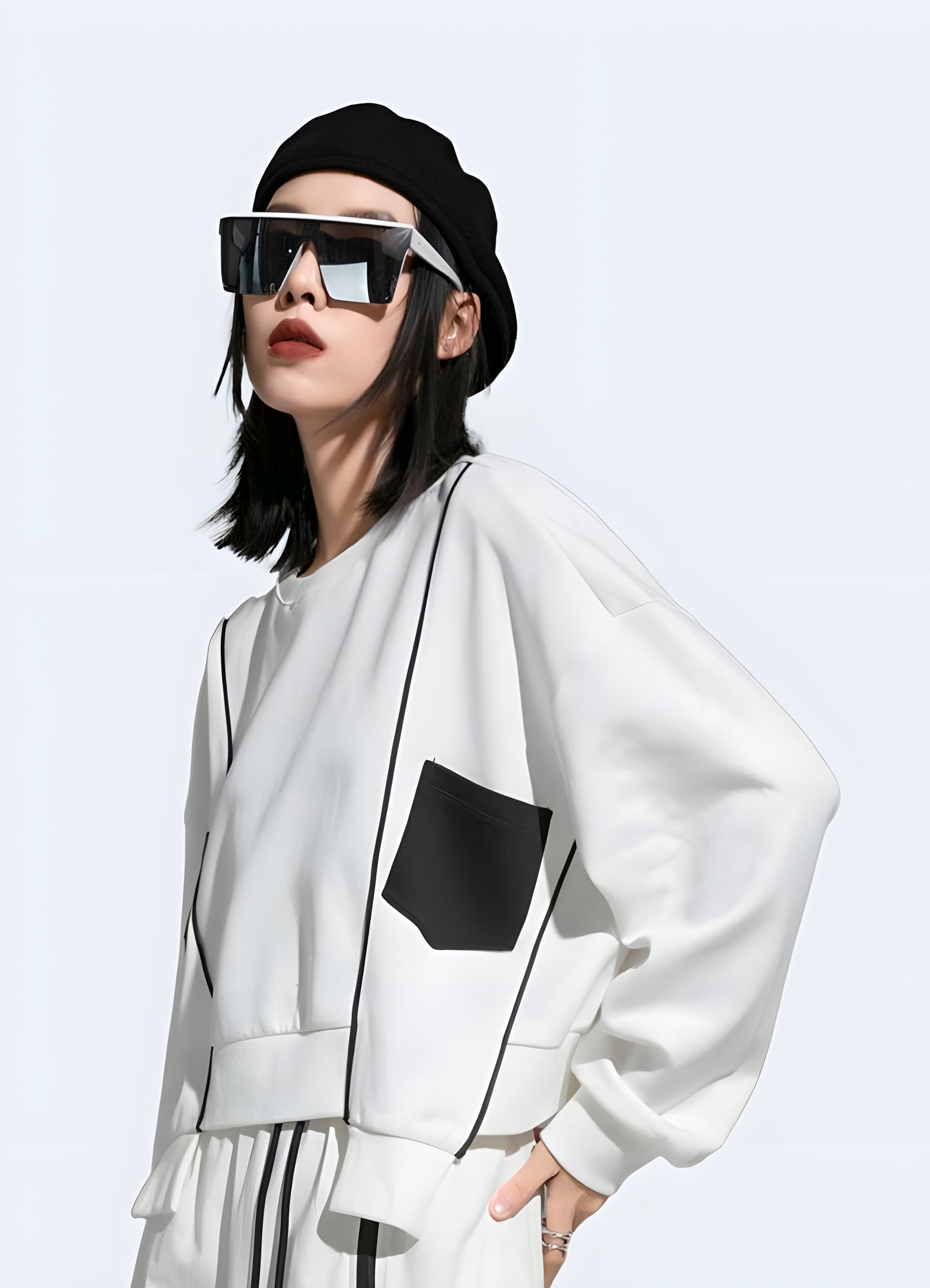 Woman wearing a women's techwear white crop sweatshirt, side view in Canada, showcasing its chic and modern fit.