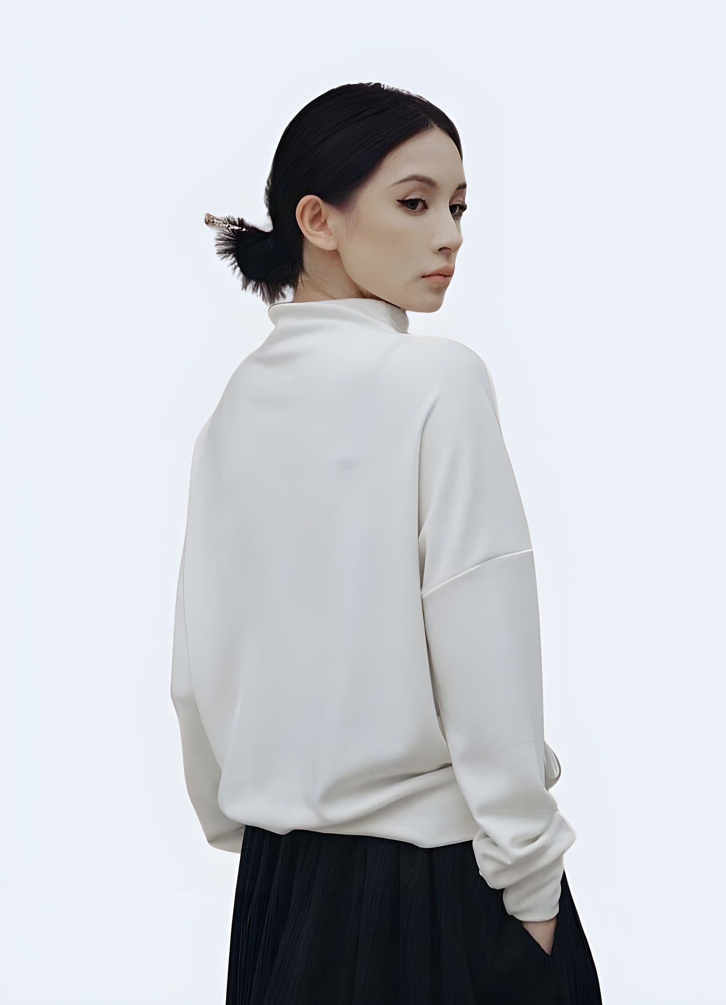 Woman showcasing the back view of a women's techwear white round-neck sweatshirt in Canada, highlighting its modern design and comfortable fit.